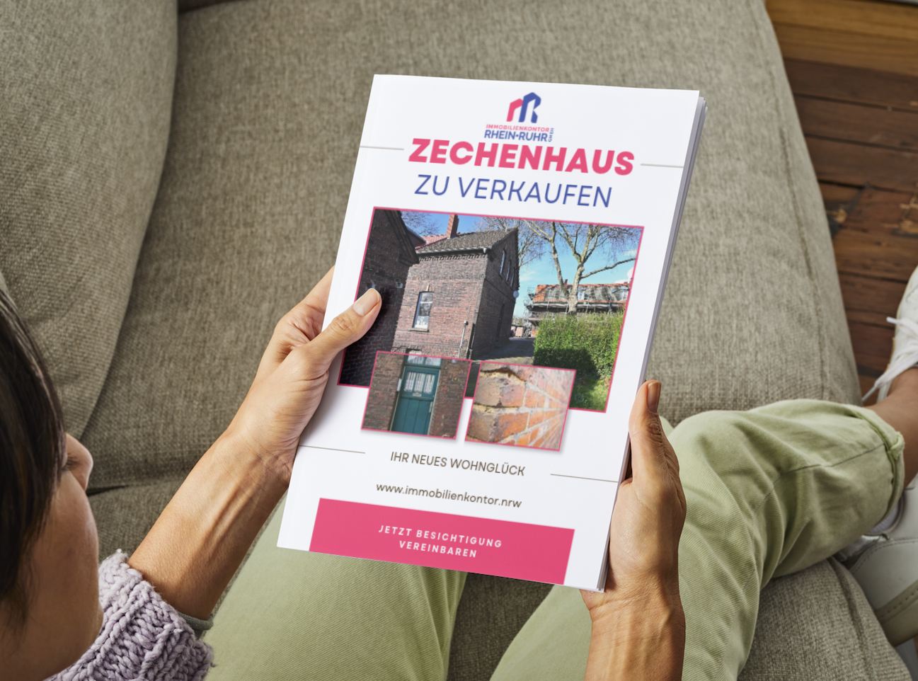 Interessentin hält eine gedruckte Immobilienbroschüre für ein Zechenhaus in den Händen